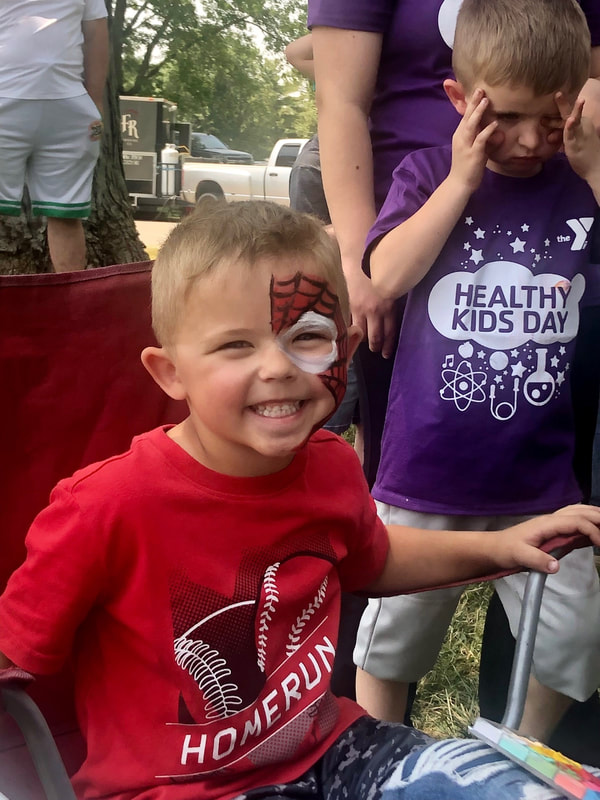 A boy with a Spiderman mask painted on his face during healthy kids day 2023